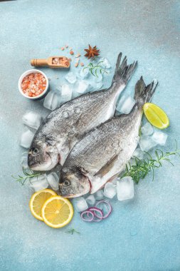 Taze pişmemiş dorado ya da arka planda limonlu çipura balığı. Restoran menüsü, diyet, yemek kitabı tarifi üst görünümü.