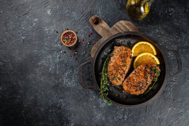 Tavada kekik ve portakallı kızarmış ördek eti. Karanlık bir arka planda. Üst Manzara. Boşluğu kopyala.
