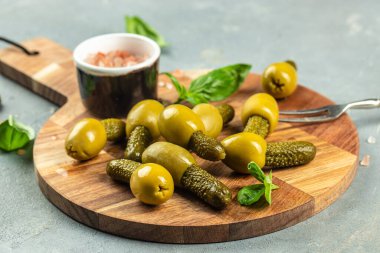 Hafif arka plan manzaralı bir kasede salatalık turşusu olan zeytinler. metin için yer.