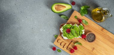 Kahvaltıda avokado tostu ya da avokado, ahududu, krem peynir ve chia tohumlarıyla öğle yemeği. Vejetaryen yemeği. Temiz yemek. Üst Manzara. Boşluğu kopyala,