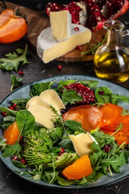 Taze yeşillikli sağlıklı salata, avokado, Camembert peyniri ve nar. Spor yemeği. Süperyiyecekler, hurma salatası. Üst Manzara. metin için boşluk kopyala.