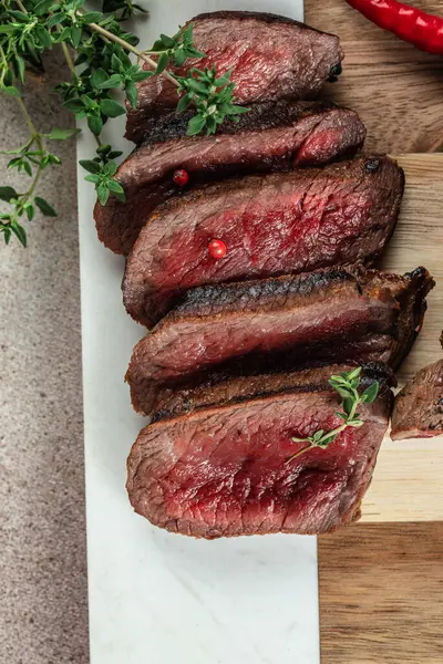 medium rare steak on an iron fork on a dark background. top view. copy space for text.