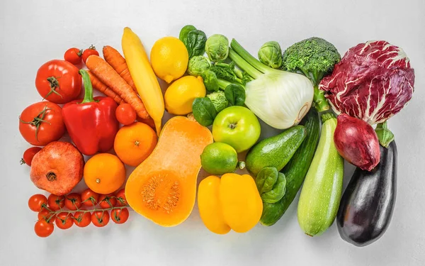 fresh organic fruits and vegetables in rainbow colors on a white background top view,