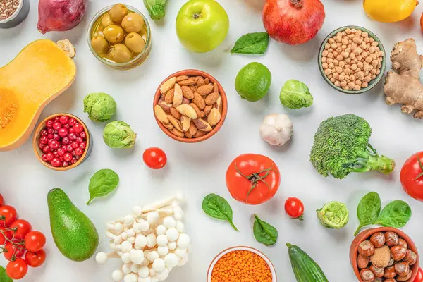 healthy food, vegetables, seeds, nuts and fruits on a white background top view.