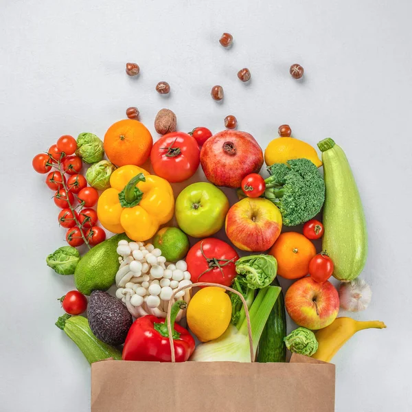 Healthy vegan vegetarian food in paper bag vegetables and fruits on white background. Delivery shopping food concept.