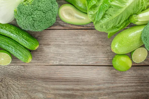 raw healthy food clean eating vegetables source. green vegetables on a wooden background, top view. copy space for text,