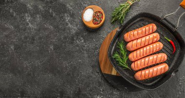 Koyu bir arka planda ızgara sosis. Üst Manzara. metin için boşluk kopyala,