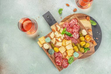 Salam, peynir, zeytin ve gül şarabı ile kesme tahtası. Üst Manzara. metin için boşluk kopyala.