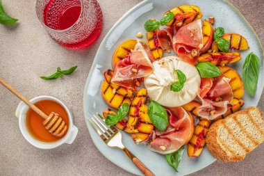 Şarap için ızgara şeftalili Caprese salatası mozzarella, jambon, fesleğen ve bal. en üstteki görünüm,