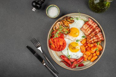 Geleneksel İngiliz kahvaltısı kızarmış yumurta, sosis, fasulye, mantar, ızgara domates ve pastırma.,
