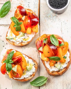 Gurme sandviçler, tost, krem peynirli bruschetta, şeftali, domates ve yeşil fesleğen yaprağı.,