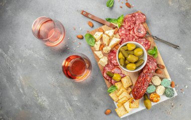 Salam, dilimlenmiş sosis, peynirli zeytin. Et antipasto tabağı ve gül şarabı.,