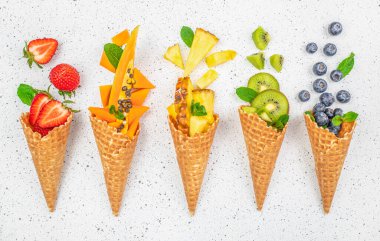 Taze kivi meyveli waffle külahları, çilek, yabanmersini, papaya ve ananas, sağlıklı yaz konsepti..