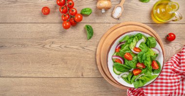 Taze domates, soğan ve yeşil yapraklı ıspanak salatası. Sağlıklı vejetaryen yemeği. Üst görünüm.