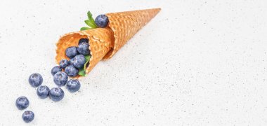 Waffle külahlı böğürtlenler, arka planda taze meyveli yaban mersinli dondurma, üst manzara. Boşluğu kopyala,