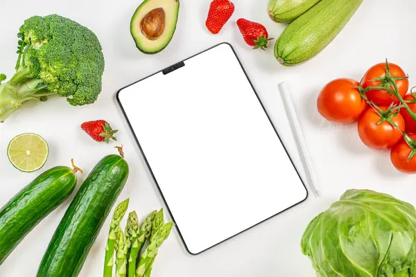 stock image Digital tablet computer with mockup white screen on organic green vegetables vegetarian healthy foodo background