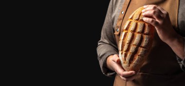 Elinde taze ekmek tutan bir adam. Ekmek ve fırın ürünleri pişirme kavramı.