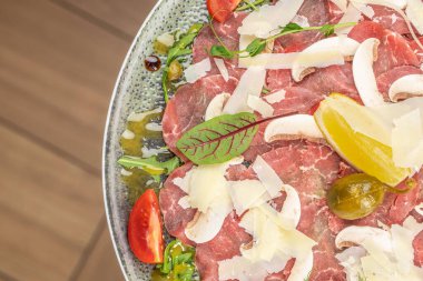 Kapari, roka ve parmesanlı geleneksel sığır eti carpaccio bir tabak, kopyalama alanı, üst görünüm,