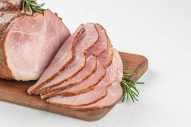 Beyaz arka planda domuz jambonu dilimleri. Tahta üzerinde dilimlenmiş soğuk füme et, üst manzara. Boşluğu kopyala.