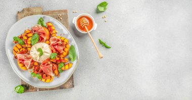 Şarap için ızgara şeftalili Caprese salatası mozzarella, jambon, fesleğen ve bal. en üstteki görünüm,