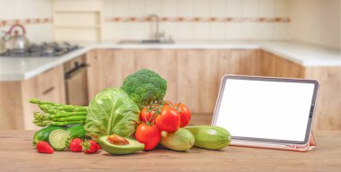 Sebzeli beyaz ekranlı dijital tablet bilgisayar. Vejetaryen sağlıklı yemek. Evde yemek pişirmek..