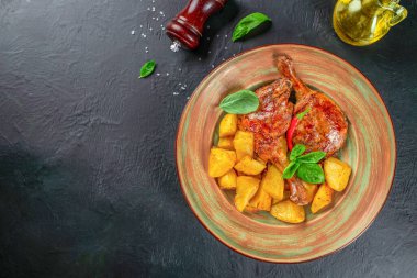 Koyu arkaplanda patatesli kızarmış ördek bacağı. Üst Manzara. metin için boşluk kopyala.