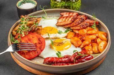 Sahanda yumurta, sosis, fasulye, mantar, ızgara domates ve pastırma tam geleneksel İngiliz kahvaltısı. Üstten Görünüm.