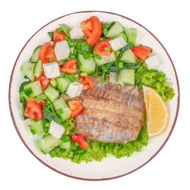 Beyaz arka planda taze yeşil salatalı ızgara balık filetosu. Diyet besleyici yemek.