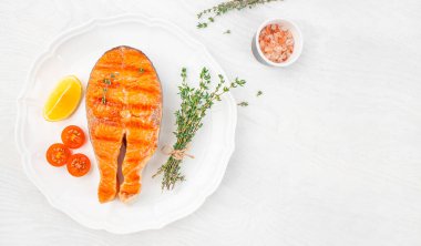 Beyaz arka plan manzaralı ızgarada pişirilmiş baharatlı kekik soslu somon bifteği. Boşluğu kopyala.