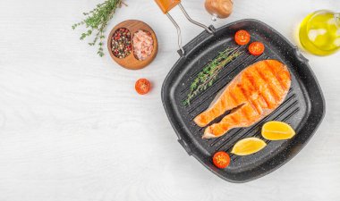 Tavada tuzlu ızgara somon bifteği, beyaz arka plan manzaralı kekik. Boşluğu kopyala.