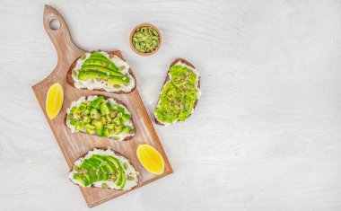 Avokado ve peynirli tost seti. Beyaz arka plan manzaralı vejetaryen kahvaltı menüsü. Boşluğu kopyala.