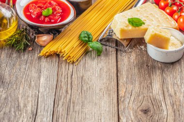 Pişirmek için malzemeli çiğ makarna. Tahta bir arka planda. Üst Manzara. Boşluğu kopyala.