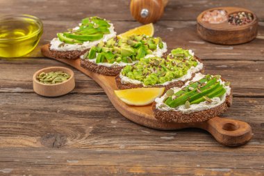 Tahıl ekmeğine krem peynirli avokado tostu. Vejetaryen gıda konsepti. Temiz yemek. Üst görünüm.