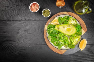 Ispanak, roka, avokado, tohum ve manzaralı yeşil vejetaryen kahvaltısı. Temiz yemek, diyet, vejetaryen gıda konsepti.