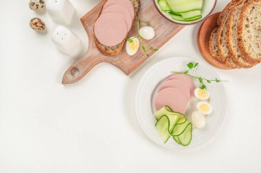 Kahvaltı dilimlenmiş jambonlu sosis ve arka planda kaynamış yumurta, üst manzara. Boşluğu kopyala.