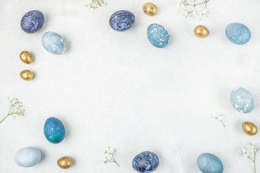 Mutlu Paskalyalar. Paskalya arkaplanını tebrik ederim. Beyaz arka planda Paskalya yumurtaları ve çiçekler. Üst Manzara. Boşluğu kopyala.