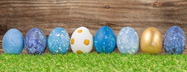 Easter holiday concept with cute handmade eggs in green grass. Festive decoration. Happy Easter clipart