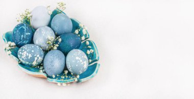 Tabakta Paskalya yumurtası. Şık altın ve mavi yumurtalar. Bayramlık Paskalya sofrası düzenleme arka planı. Kopyalama alanı olan üst görünüm.