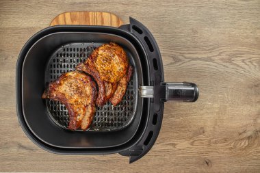 Kızarmış domuz bifteği kızartma makinesinde. Sepetin içinde sıcak hava dolaşarak yağ yok. Üst Manzara. Boşluğu kopyala.