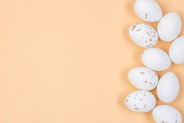 Minimalist Paskalya dairesi zarif dekorasyonlarla benekli yumurtalar içeriyor. Yaratıcı tasarımlar için sarı zemin üzerinde Paskalya beyaz yumurtası şeklinde kompozisyon.