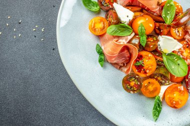 Prosciutto salatası, kiraz domatesleri, fesleğen yapraklı krem peynir, antipasto, restoran menüsü, diyet, yemek tarifi üst görünümü.,