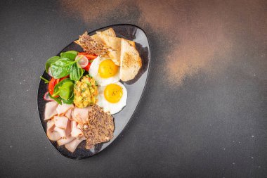 Yağda yumurta, jambon, avokado ve taze salata. Lezzetli dengeli gıda konsepti. metin için boşluk kopyala. en üstteki görünüm