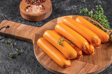 Ahşap bir tahtanın üstünde kaynamış sosisler, üst manzara. Boşluğu kopyala.