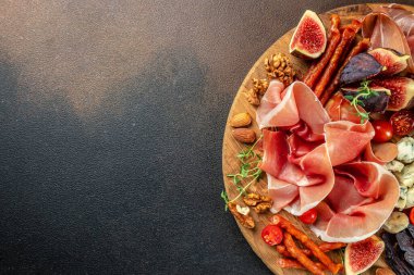 Peynir ve meze çeşitleri. Kuru jambon, incir ve peynirli jambon dilimleri. Uzun afiş biçimi. en üstteki görünüm.