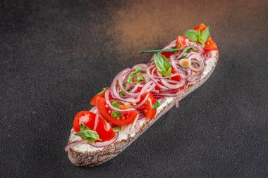 Lezzetli İtalyan domatesli, otlu ve yağlı sarımsaklı peynirli ekmek, koyu arkaplanda. Üst Manzara. metin için boşluk kopyala.