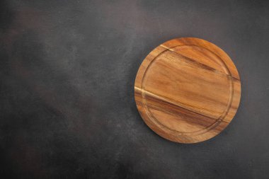Yuvarlak tahta. Mutfak arka planı boş ahşap kesim pizza tahtası koyu ahşap arka plan manzaralı.