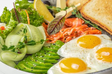 Tütsülenmiş somonla kahvaltı, güneşli yan yumurtalar, avokado sebzeleri salata ve tost, pankart, menü, yemek tarifi üst görünüm.