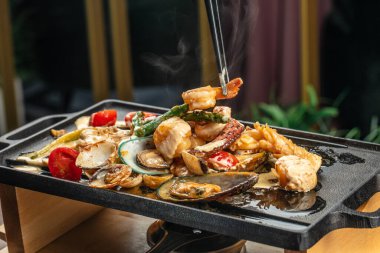 İçinde deniz ürünleri, ahtapot, midye, karides ve kuşkonmaz olan taze bir yemek.,