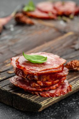 Ahşap arka planda dilimlenmiş kuru salam. dikey görüntü. metin için yer.