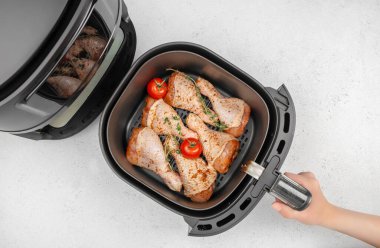 Çiğ tavuk budu, sebzeli ve domatesli kızartma sepeti beyaz mutfak masasında pişirilmeye hazır. Üst Manzara. Boşluğu kopyala